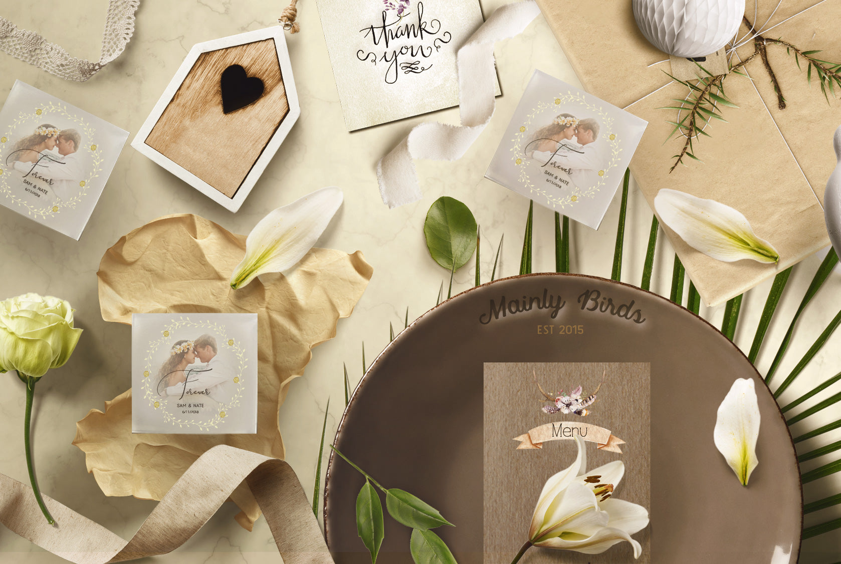 Three custom soaps, embedded with a photo of a couple and 'forever' text, arranged with flowers, leaves, and twine. A plate with the 'Mainly Birds Est 2015' logo is also shown.
